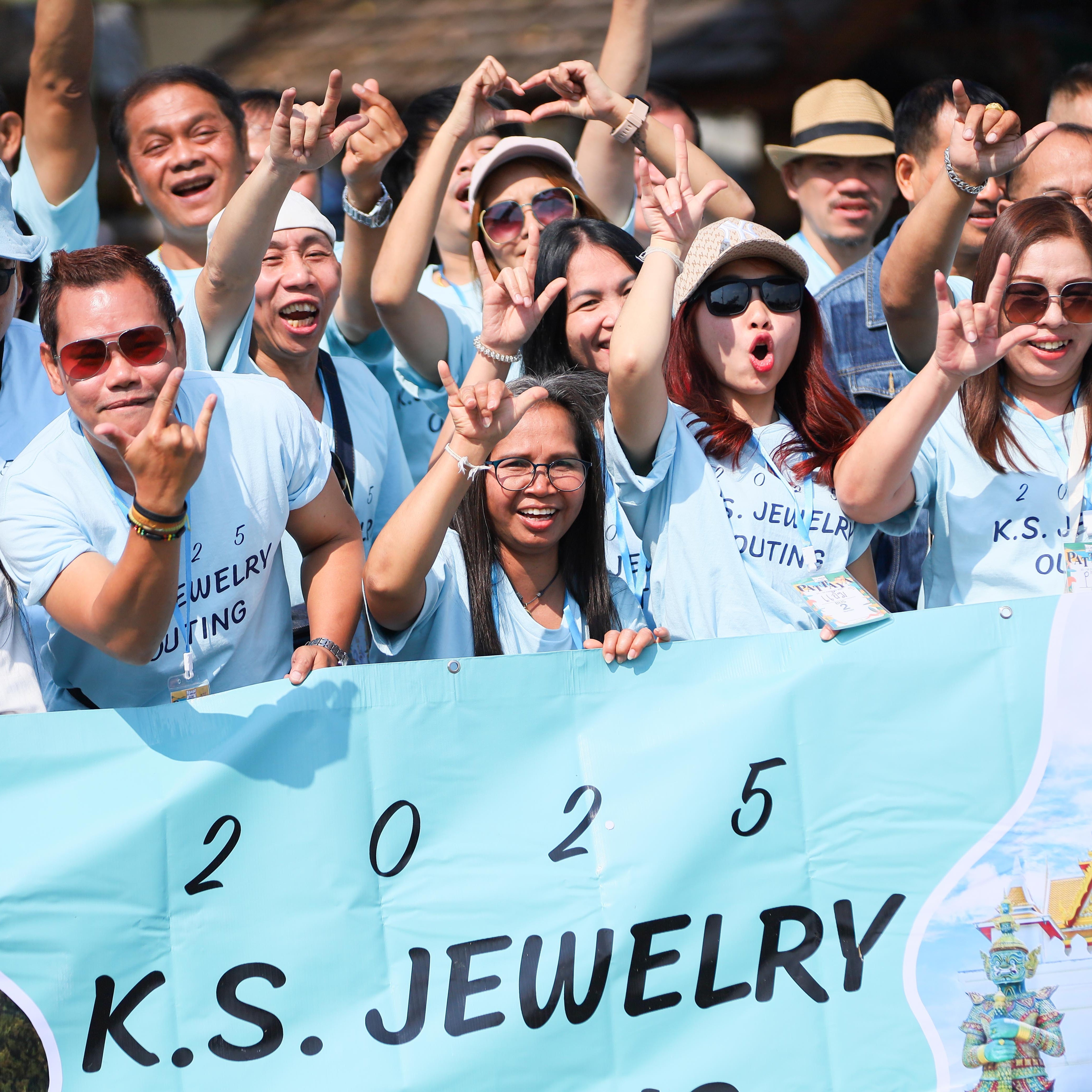Group of people wearing matching shirts with a banner and map, indicating a travel or event theme.